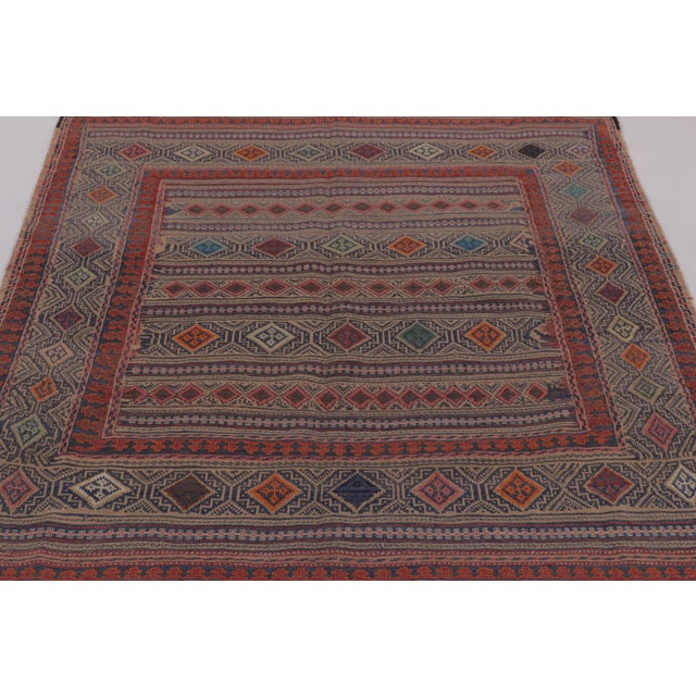 Made with handwoven wool circa 1950-1960, this 5x6 vintage Persian Kilim, originating from the Larkhabi region of...