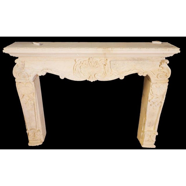 This exquisite 20th-century limestone fireplace mantle draws from the graceful curves and ornate detailing of the Louis XV...
