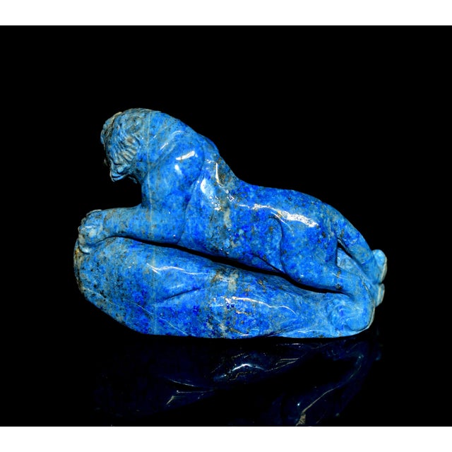A masterfully hand-carved sculpture of a tiger, meticulously fashioned from a single piece of natural lapis lazuli. The...