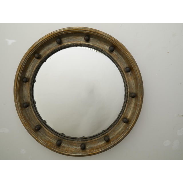 An English turn of the century silver leaf convex bullseye mirror from the early 20th century, with ebonized accents and...