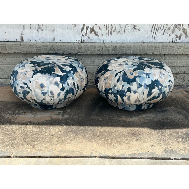This charming pair of vintage ottomans has been newly reupholstered in a striking watercolor-inspired floral fabric...