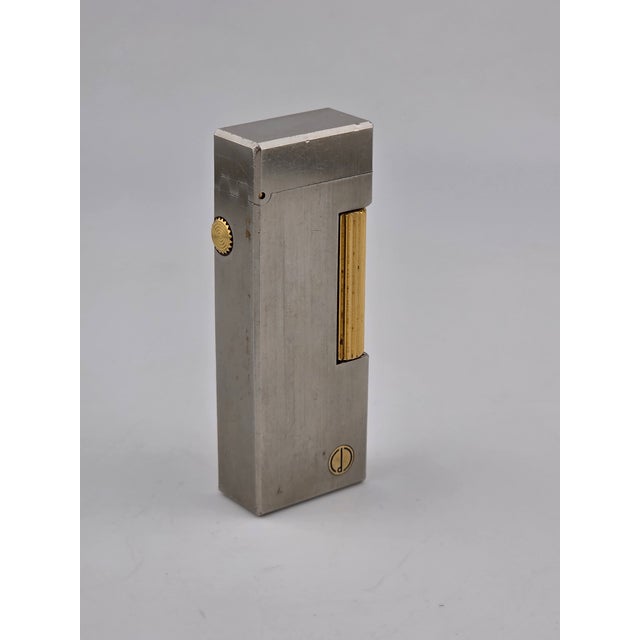 The product is a rare vintage Dunhill coral gas lighter with the D logo, featuring a silver and gold design. Made in...