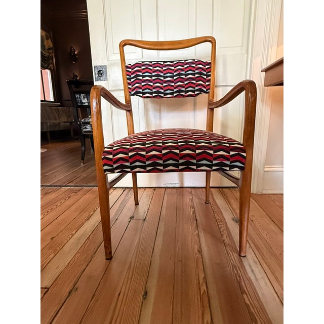 Easy chair in a wood frame, fluid lines give a sculptural elegant detail to armrests. originally designed by John Van...