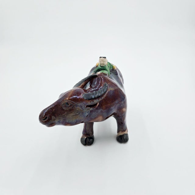 A 19th-century Chinese figure of a water buffalo with a small boy. Some small repairs.