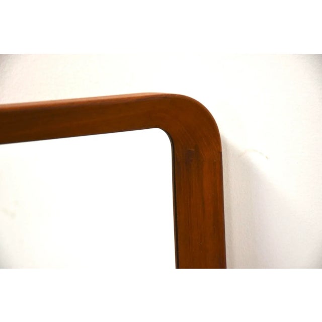A mid century modern teak framed mirror with rounded sides made in Denmark.