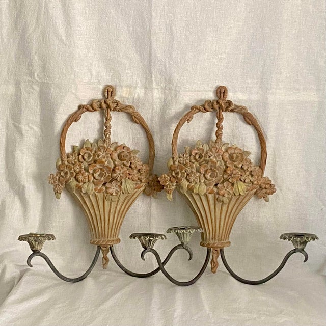 A pair of candle sconces with 2 candle holders on each sconce. Flower basket with a handle design.