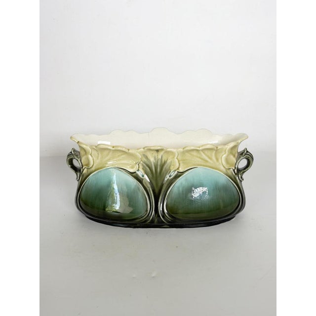 A superb Art Nouveau-style majolica cache-pot, crafted from glazed ceramic and adorned with relief decoration inspired by...
