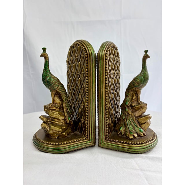 A striking pair of vintage peacock bookends featuring rich green tones with brass-toned accents. Each bird is perched on a...