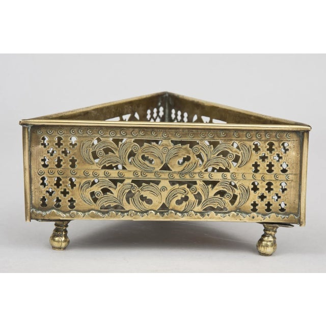 Georgian brass triangular coaster with pierced and etched sides in acanthus leaf designs and cross-like patterns raised on...