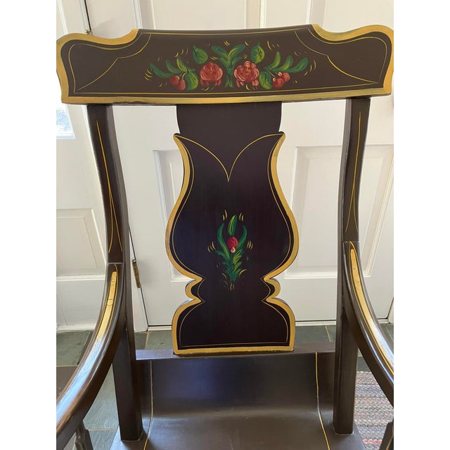 Mid-20th century farmhouse style folk art painted wooden splat-back rocking chair with plank seat and scroll arms. Brown...