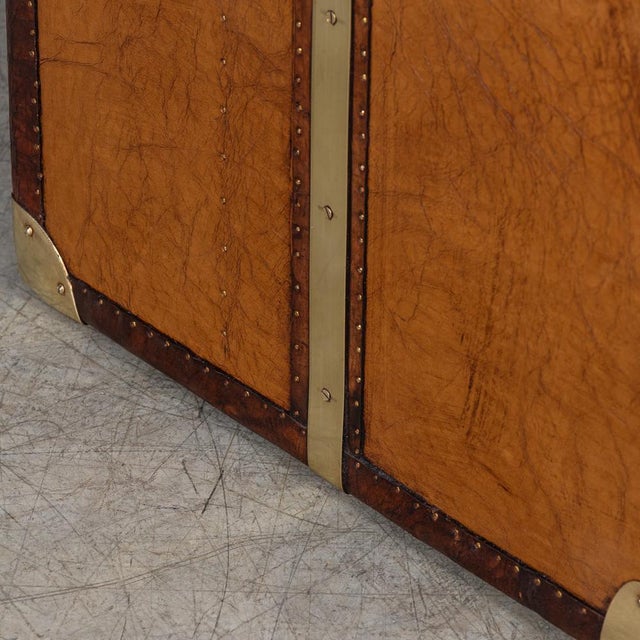 A leather-clad Army and Navy style trunk, crafted in England in the late 20th century, exuding rugged sophistication and...