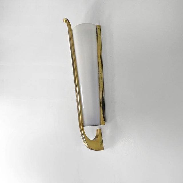 Italian mid-century modern white acrylic glass and brass, 1950s Applique with a conical base and an elongated shape. The...