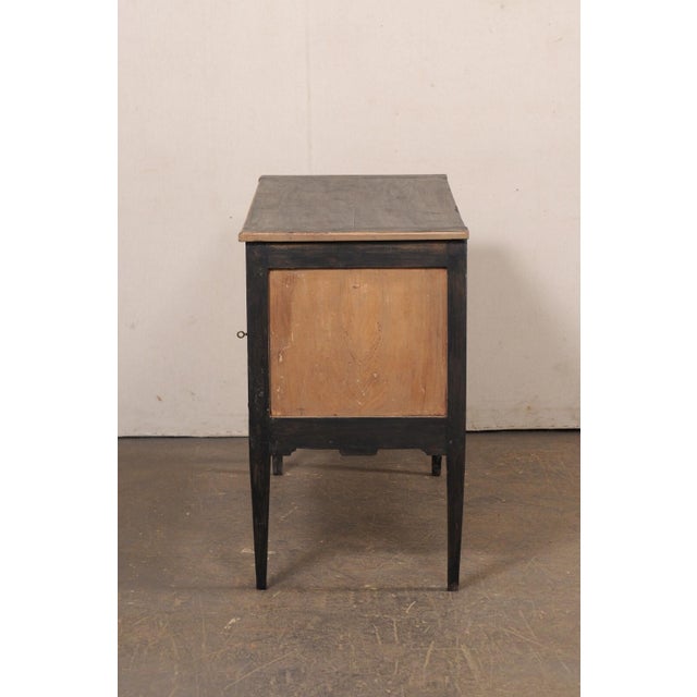 A French Neoclassic style painted wood two-drawer chest from the 19th century. This antique chest from France features a...