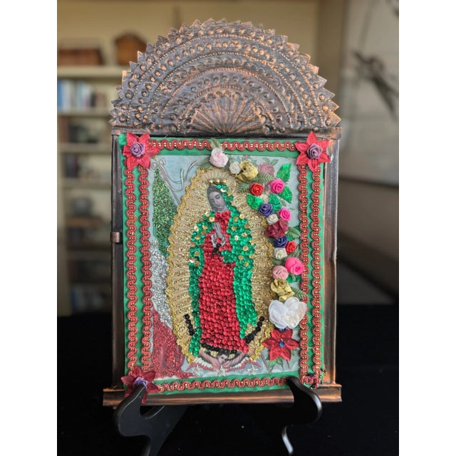 This vintage Mexican nicho shrine is a mixed-media devotional work assembled from metal, paper, and applied decorative...