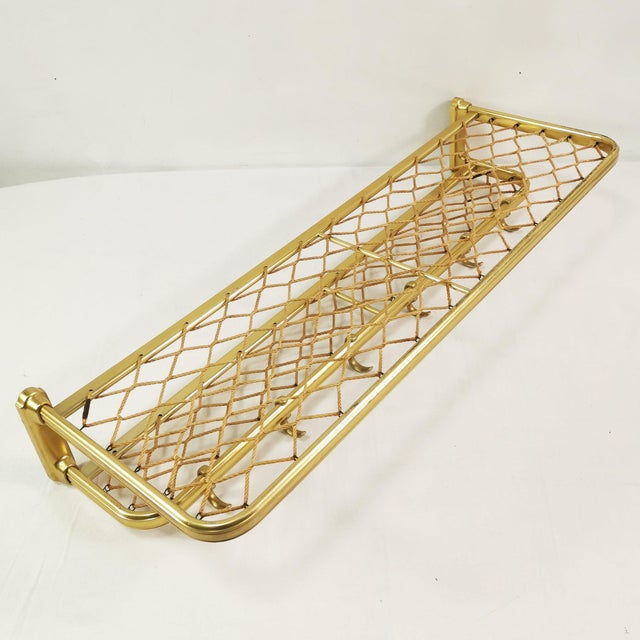 Wall-mounted coat rack, German origin, 1960s. It features 6 hooks for hanging clothes, an upper shelf, and a smaller lower...