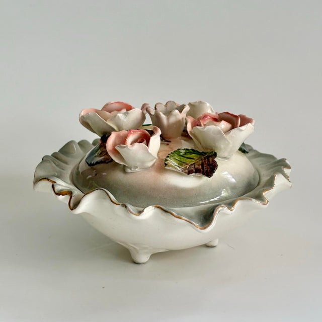 A delicate vintage Capodimonte-style porcelain lidded bowl, richly adorned with hand-sculpted pink roses and green...