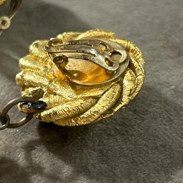 This stunning pair of vintage earrings from the 1960s exudes opulence and bold sophistication. Crafted with intricate...