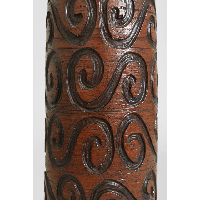 Vintage ceramic table lamp featuring a tall bottle-form silhouette with hand-carved spiral relief and a rich reddish-brown...