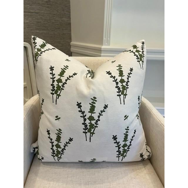 A refined linen blend pillow featuring hand drawn Eucalyptus branches in layered shades of bottle green and olive.