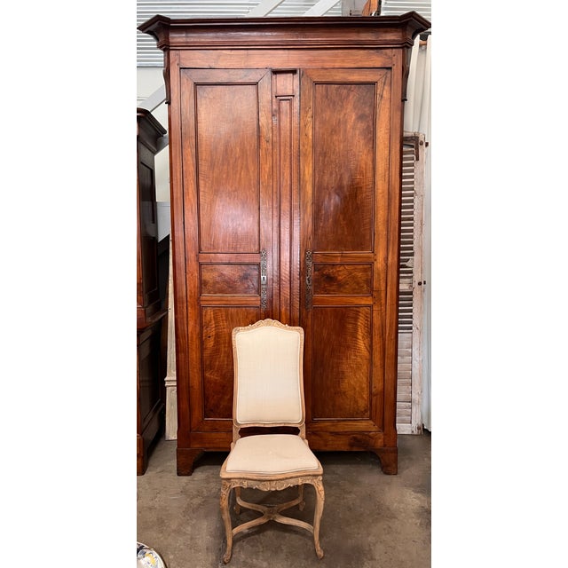 An impressive 19th c. French Restoration style armoire, handcrafted of solid walnut accented with rich fruitwood inlay. A...