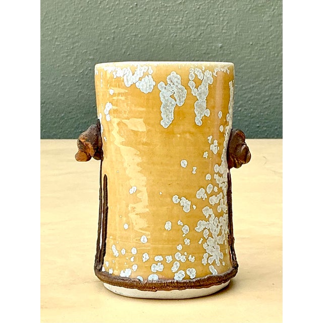 This original studio pottery vase is a compelling example of Mid-Century Modern ceramic art, blending a rugged Brutalist...
