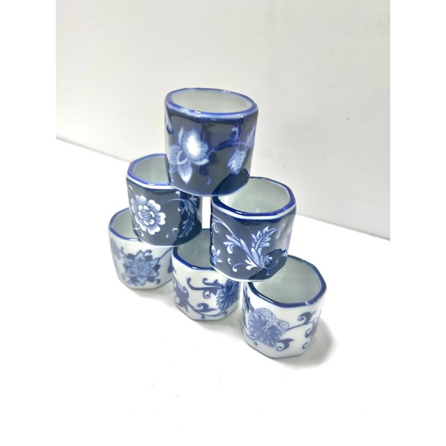 A charming set of four vintage porcelain napkin rings in classic blue and white chinoiserie patterns. Each ring features...