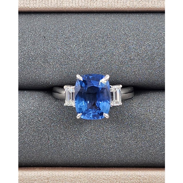This exquisite cocktail ring showcases a 4.36 ct certified natural cushion-cut blue sapphire as its centerpiece, set in...