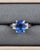 This exquisite cocktail ring showcases a 4.36 ct certified natural cushion-cut blue sapphire as its centerpiece, set in...