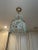 This French pendant chandelier has a soft gold frame. It has the original blue raindrops and crystals hanging on 2 tiers...