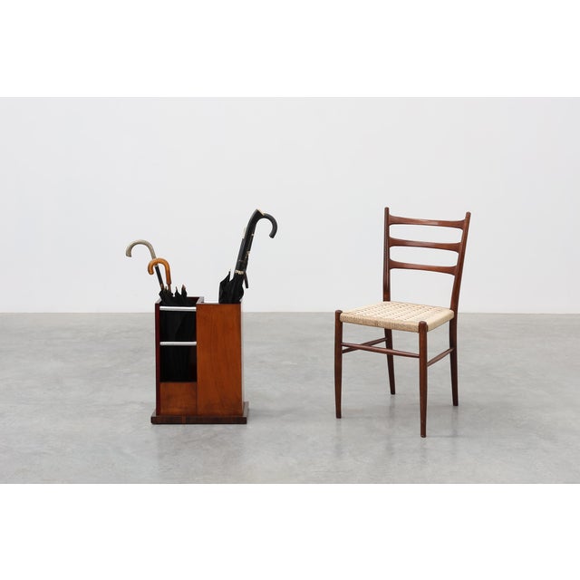 An elegant and rare early Art Deco umbrella stand from France, circa 1910, combining warm wood craftsmanship with sleek...