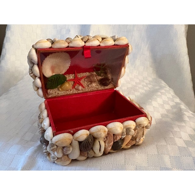This beautifully detailed shell; encrusted box has a seascape inside the lid behind a clear barrier. The interior and...