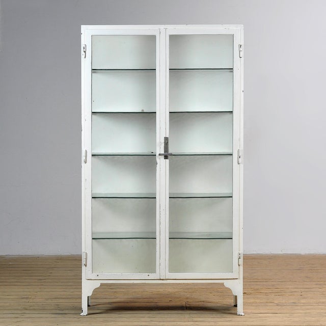 Medical cabinet from the 1930s, manufactured in Hungary. This characterful display cabinet is crafted from thick iron and...