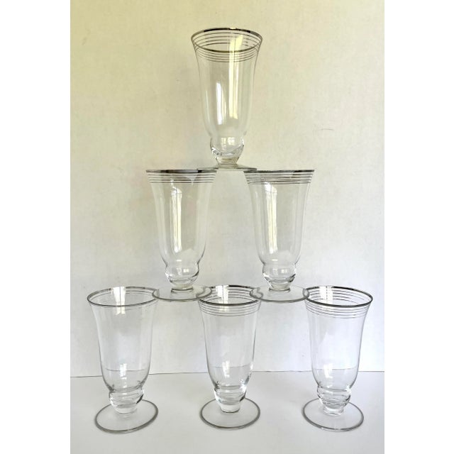 Here is a wonderful set of 6 tall glasses with silver painted details. There are silver lines around the top and one...
