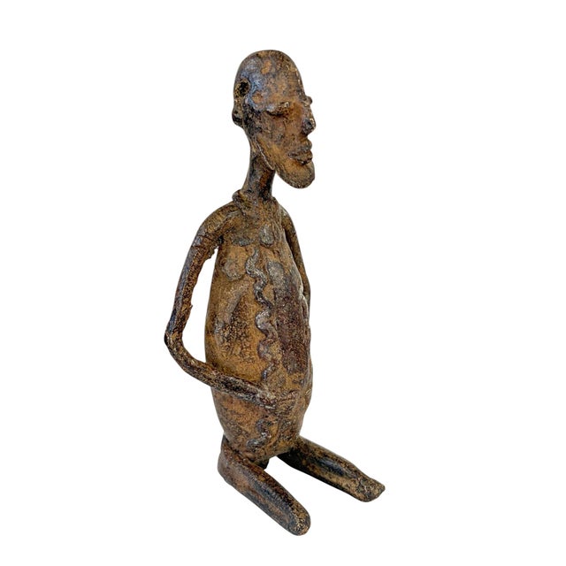 Superb vintage dogon bronze Mali. This bronze is cast over the stone into the form of a seating male holding his belly...