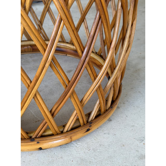 A beautifully crafted vintage rattan side table featuring a sculptural drum-form silhouette and intricate woven details....
