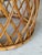 A beautifully crafted vintage rattan side table featuring a sculptural drum-form silhouette and intricate woven details....