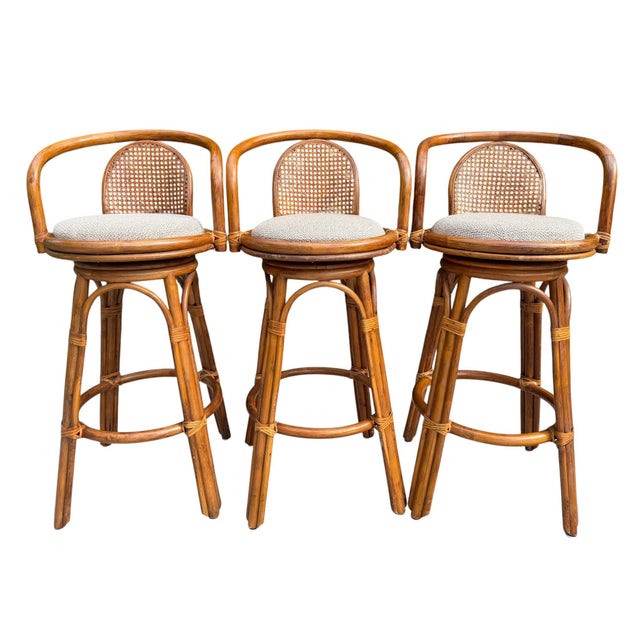 A well-executed set of vintage swivel bar stools with a clean organic modern profile. Crafted from warm-toned rattan with...