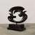 Abstract bronze sculpture featuring fluid, interwoven forms that evoke the motion of birds or doves (or seagulls) in...