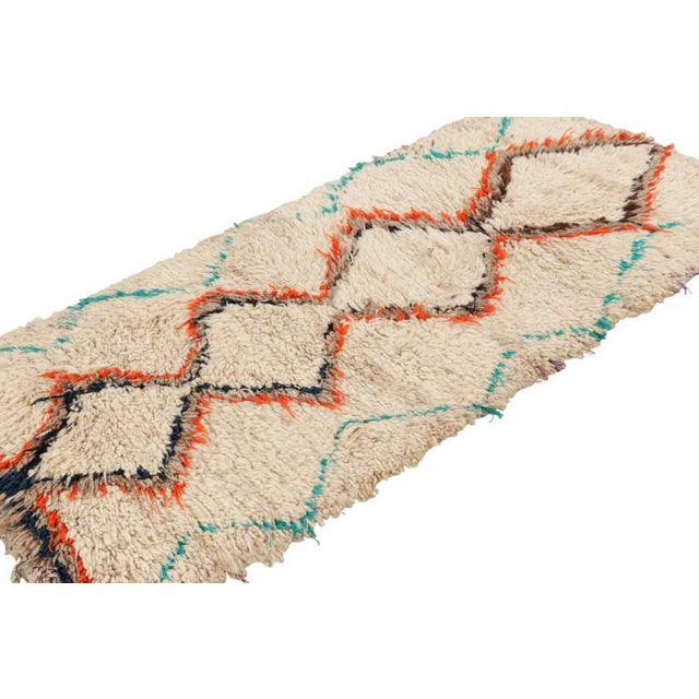 Hand-knotted in wool and originating from Morocco circa 1950-1960, this 3x6 vintage Moroccan rug is an extremely rare...