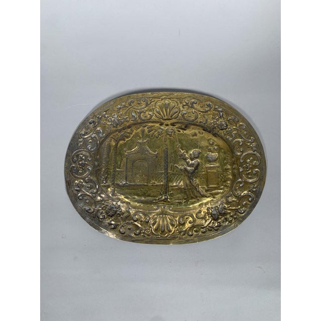 17th-century brass offering dish with "Chinese" decoration. The brass is finely engraved with scrolling foliage and scenes...