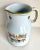 Here is a wonderfully made ceramic pitcher with handle that was made in Italy. Signed on the bottom. The pitcher has trim...