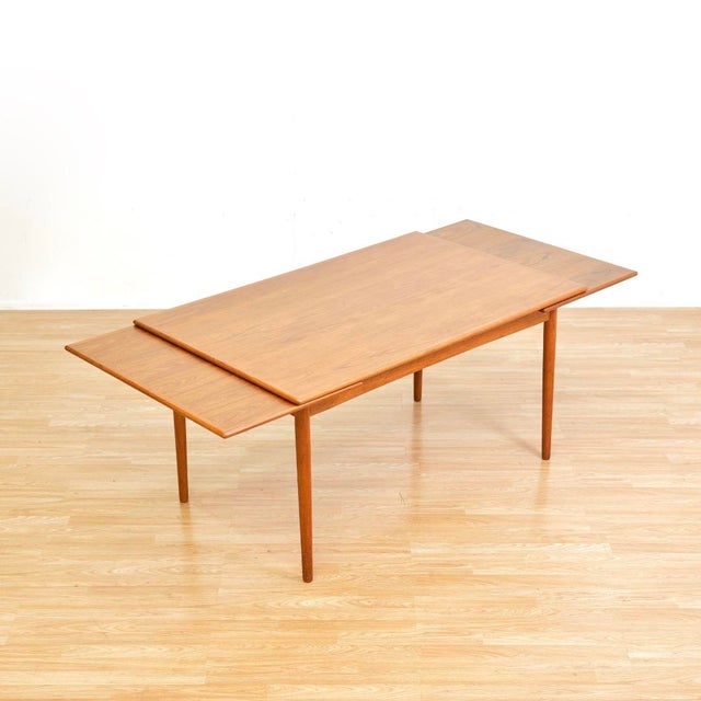 This large 1960s Danish modern draw leaf teak extending dining table was manufactured by Georg Petersens Mobelfabrik of...
