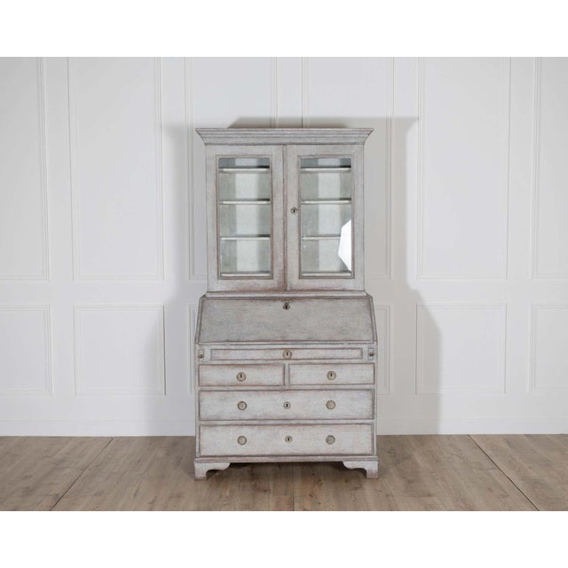 An exceptional early 19th-century Swedish secretary cupboard, circa 1810–1830, finished in soft grey with a beautifully...