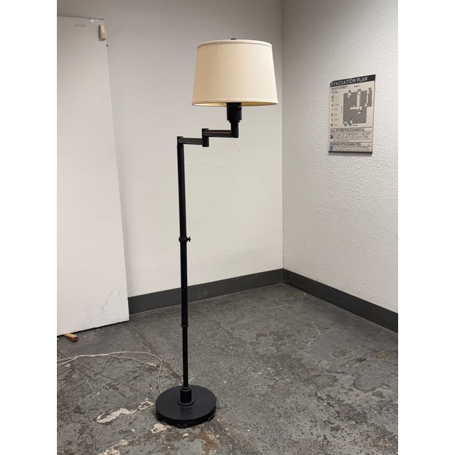 Design Plus Gallery presents a Library Style Swing-Arm Floor Lamp. This floor lamp has a metal frame with a round weighted...