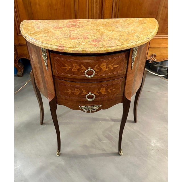 This is a Louis XV style mahogany inlaid commode with a sienna marble top over two inlaid drawers, supported by slender...