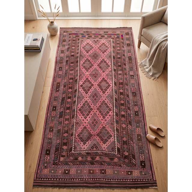 A long handwoven Maimana kilim from northern Afghanistan in a warm rose ground, worked with chocolate brown, slate blue...