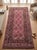 A long handwoven Maimana kilim from northern Afghanistan in a warm rose ground, worked with chocolate brown, slate blue...