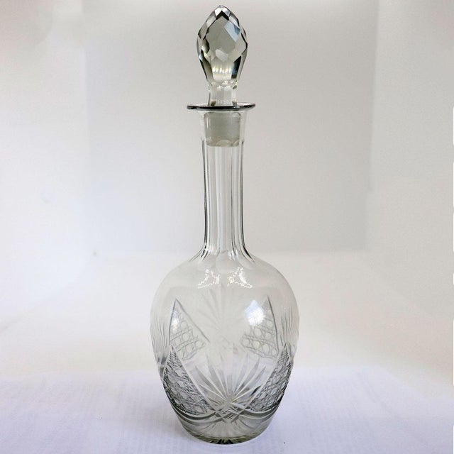 DETAILS Antique clear glass decanter with bulbous body and long neck and faceted stopper. With fan and honeycomb pattern....