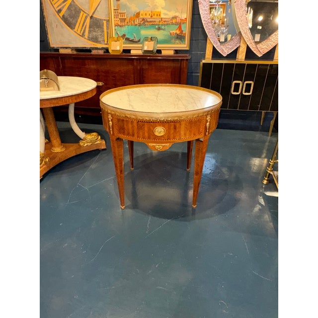 The 19th c. French Louis XVI Inlaid Center Table is a luxurious and elegant piece of furniture that exudes sophistication...