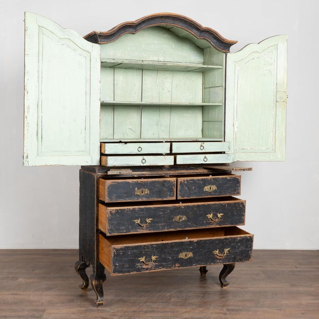 Late 18th century Swedish wedding cabinet crafted in pine. The cabinet features a black painted finish that was applied...
